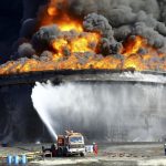 Firefighters work to put out the fire of a storage oil tank at the port of Es Sider in Ras Lanuf