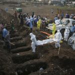Health workers carry the body of an Ebola victim for burial at a cemetery in Freetown