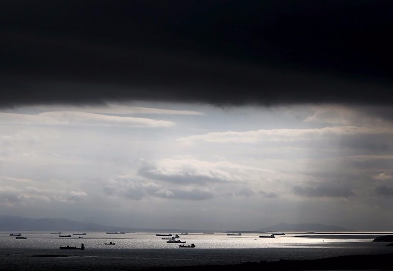 Cargo ships are seen sailing under storm clouds in the sea near the port of Piraeus in Athens, Greece in this March 5, 2015 file photo. To match Special Report EUROZONE-GREECE/SHIPPING REUTERS/Alkis Konstantinidis/Files