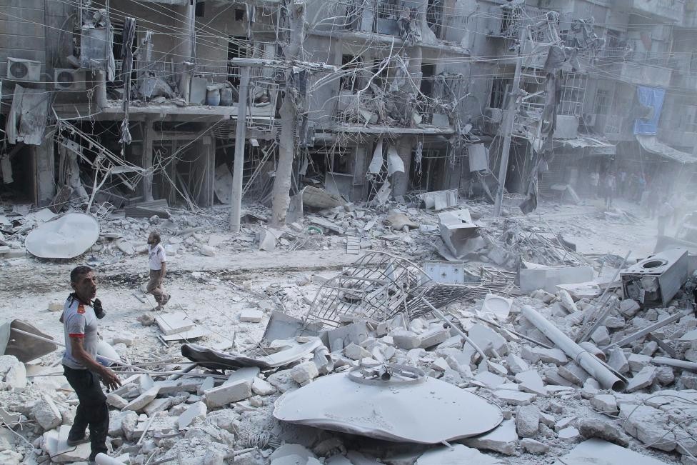 Residents look for survivors at a damaged site after what activists said was a barrel bomb dropped by forces loyal to Syria's President Bashar al-Assad in the Al-Shaar neighbourhood of Aleppo, Syria, September 17, 2015. REUTERS/Abdalrhman Ismail